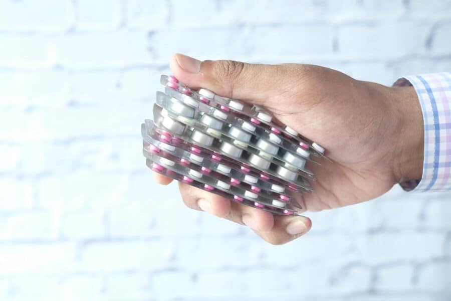 Can I Take Ibuprofen with Meloxicam? A hand holding a stack of blister pill packs.