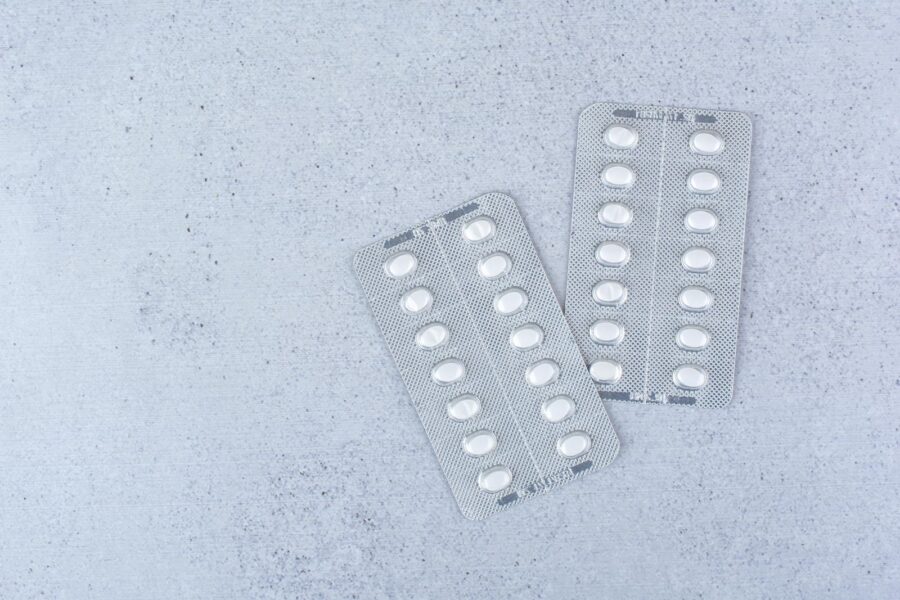 Is Tizanidine a Controlled Substance? Blister pill packs on a gray backtround.